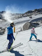 Des enfants descendent la piste de manière sportive et avec les genoux pliés pendant les cours de ski pour enfants (4-12 ans) - tous niveaux de l'école de ski Thomas Spenzel.