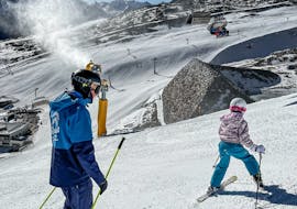 Kinderen skiën sportief en met gebogen knieën de piste af tijdens de kinderskilessen (4-12 jaar) - alle niveaus bij de skischool Thomas Spenzel.
