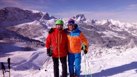 Two skiers are standing on top of a mountain during a private ski lesson for adults of all levels with Skischule Thommi at Nassfeld.