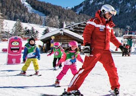 Ski instructor with young skiers in the Kinderland of Selva di Val Gardena during one of the kids ski lessons for beginners half day.