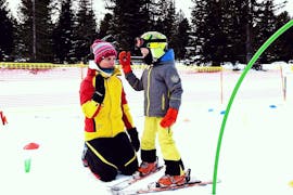Een kleine skiër viert zijn succes tijdens privé skilessen voor kinderen van alle leeftijden met Richi's Skischule Kreischberg.
