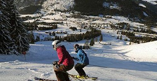 Adult Ski Lessons for All Levels from Ski & Snowboard School Ostrachtal Two adults skiing at Adult Ski Lessons for All Levels from Ski & Snowboard School Ostrachtal.