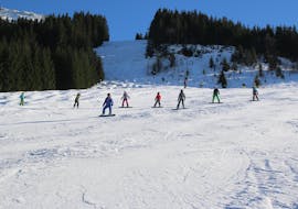 Snowboarders op de piste bij snowboardles voor tieners en volwassenen van alle niveaus van Ski & Snowboardschool Ostrachtal.
