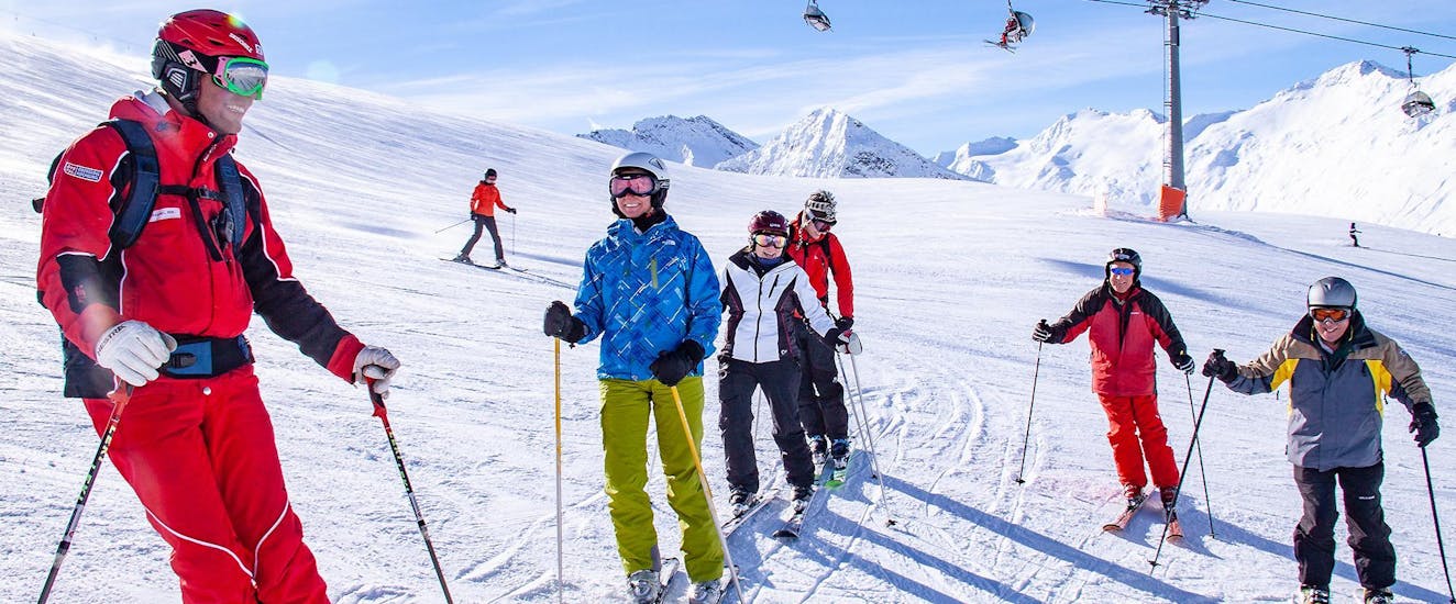 A ski instructor is teaching a group of adults in Adult Ski Lessons for Beginners.