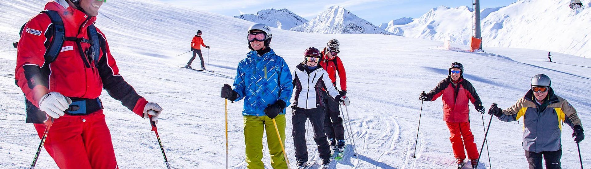 Three adult skiers and their instructor are standing in the snow, smiling during their Adult Ski Lessons for Beginners with skischule Obergurgl.