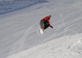 A snowboard instructor from the Busslehner Ski School in Achenkirch does a trick for advanced snowboarders during the snoboarding lessons for kids and adults.