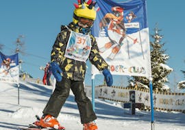Ein kleiner Skifahrer fährt während seinem Kinder-Skikurs "BOBO" mit der Skischule Busslehner Achenkirch im Kinderland durch die Tore.