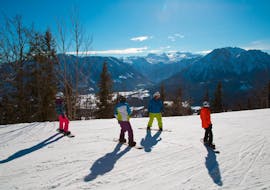 Ein Snowboardlehrer und eine kleine Gruppe Snowboarder während dem Privaten Snowboardkurs für Kinder & Erwachsene aller Levels mit Snow & Mountain Sports Loitzl Loser.