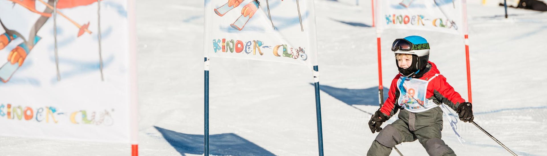 Ein kleiner Skifahrer fährt während dem Kinder-Skikurs "BOBO´s Kids-Club" für Anfänger mit der Skischule Busslehner Achkirch die Piste im Kinderland hinunter.