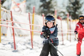 A little skier is pulled up the mountain in the kids ski lessons "BOBO's Kids-Club" for beginners with the Busslehner Achkirch Ski School.