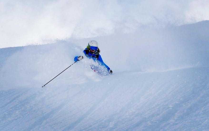 A ski instructor is mastering a snowy slope in the ski resort of Sölden during a Off-Piste Skiing Tours for Adults - All Levels organized by the ski school Ski- und Snowboardschule SNOWLINES Sölden.