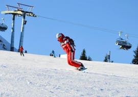 Un istruttore di snowboard sulle piste durante le lezioni private di snowboard per bambini e adulti di tutti i livelli presso la Schi- & Snowboardschule Radstadt con la Schi- & Snowboardschule Radstadt.