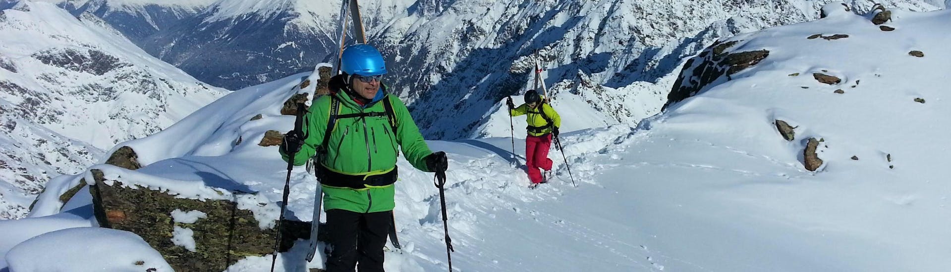 A private ski touring guide from the ski school Ski- und Snowboardschule SNOWLINES Sölden is showing the magnificent view of the snowy peaks of the ski resort of Sölden to a participant of the Private Ski Touring Guide.