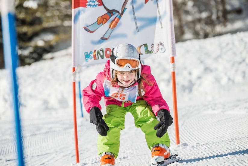 Eine kleiner Skifahrerin fährt während ihrem privaten Kinder-Skikurs mit der Skischule Busslehner in Achenkirch die Piste hinunter.