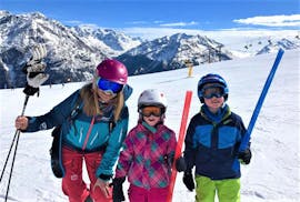 Zwei Teilnehmer des Angebots Privater Kinder Skikurs - Alle Altersgruppen der Ski- und Snowboardschule SNOWLINES Sölden lächeln gemeinsam mit ihrem Skilehrer in die Kamera.