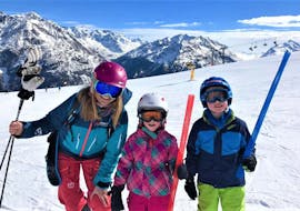 Deux participants aux cours particuliers de ski pour enfants de tous âges organisées par l'école de ski Ski- und Snowboardschule SNOWLINES Sölden à Sölden sourient à la caméra avec leur moniteur de ski.