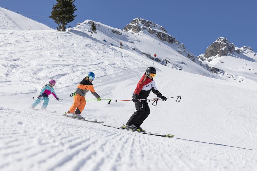 Een groep tieners rijdt achter elkaar de piste af tijdens hun privé skilessen voor kinderen van alle leeftijden in Stubai.