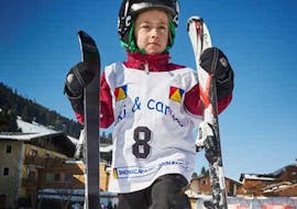 A boy holding his skis during his private ski lessons for kids of all ages with Snowacademy Saalbach.