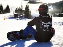 A snowboarder in the skiing area Spitzingsee during his kids & adults snowboarding lessonsfor all levels with the ski school Snowcamp Martina Loch.