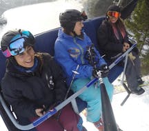 Adult skiers in the ski lift during their private ski lessons for adults for all levels with the ski school Snowcamp Martina Loch in the ski area Spitzingsee.