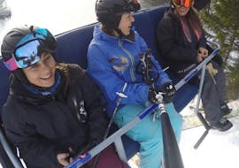 Adult skiers in the ski lift during their private ski lessons for adults for all levels with the ski school Snowcamp Martina Loch in the ski area Spitzingsee.