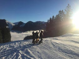 A group in the Spitzingsee ski area during their private snowboarding lessons for kids & adults with the skis school Snowcamp Martina Loch.