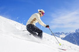 Uno sciatore sta scendendo lungo un pendio innevato durante le sue lezioni private di sci fuori pista per adulti - tutti i livelli con la scuola di sci Prosneige Méribel.
