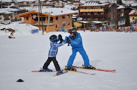 A kid and instructor practising during kids ski lessons for beginners with ski school Aktiv in Wildschönau.