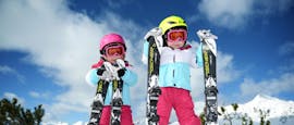 Two girls are waiting for their kids ski lessons for beginners with ski school Ruhpolding at the Westernberg ski area to be started.