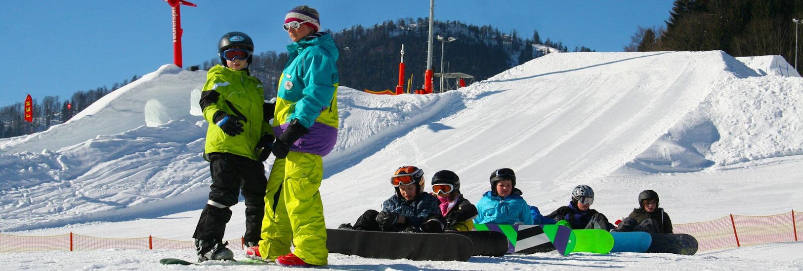 Some people are taking snowboarding lessons for beginners with ski school Ruhpolding at the Westernberg ski area.
