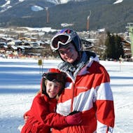 A ski instructor from the  Ski School Ellmau Hartkaiser with a child at the private ski lessons for kids for all levels.