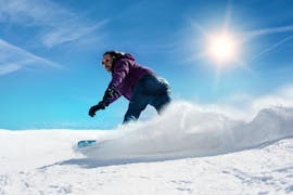 Uno snowboarder scivola sulle piste con la Scuola di Sci Ellmau Hartkaiser nell'ambito delle lezioni private di snowboard per tutti i livelli e le età.