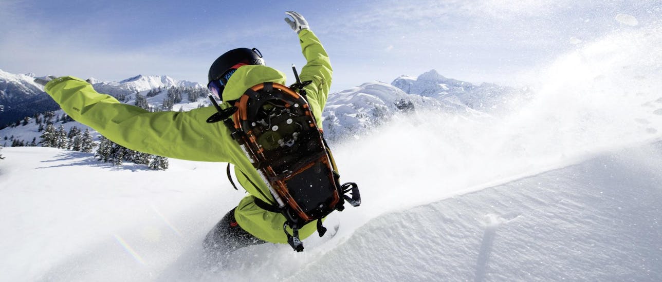 Ein Snowboarder fährt im Tiefschnee während des privaten Snowboardkurses mit der Skischule Ruhpolding.