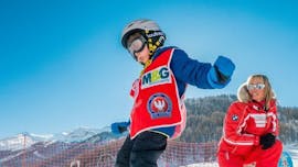 Sotto la supervisione di un maestro di sci della scuola di sci ESF Ski School Val d'Isère, un bambino fa grandi progressi sugli sci durante le lezioni di sci per bambini "Max 8" (5-12 anni) - Advanced.