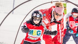 Un bambino muove i primi passi sugli sci durante le lezioni di sci per bambini "Giardino delle nevi" (4-5 anni) - Principianti nell'ambiente a misura di bambino della scuola di sci ESF Ski School Val d'Isère.