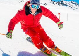 Bajo la supervisión de un monitor de la escuela de esquí ESF Ski School Val d'Isère, un esquiador disfruta del esquí paralelo en las clases de esquí para adultos - Todos los niveles.
