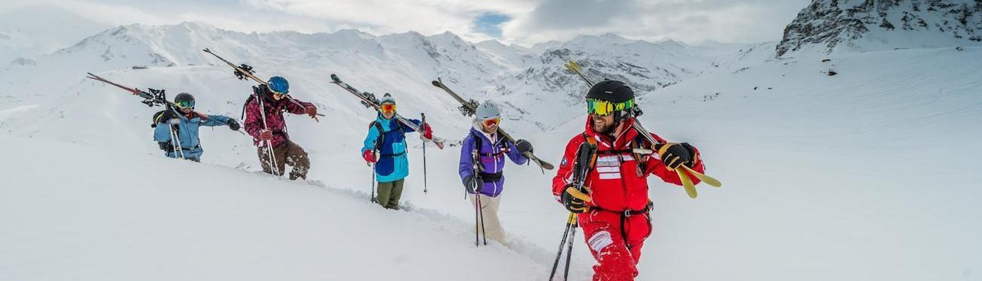 Des passionnés de ski prennent de la hauteur pendant leur Cours de ski freeride - Tous âges pour profiter de la liberté du ski feeride sous la supervision de leur moniteur certifié de l'école de ski ESF Val d'Isère.