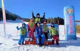 bambini e maestro di sci alla premiazione dopo la settimana di lezioni di sci per bambini da 4 anni con la scuola di sci Dobbiaco