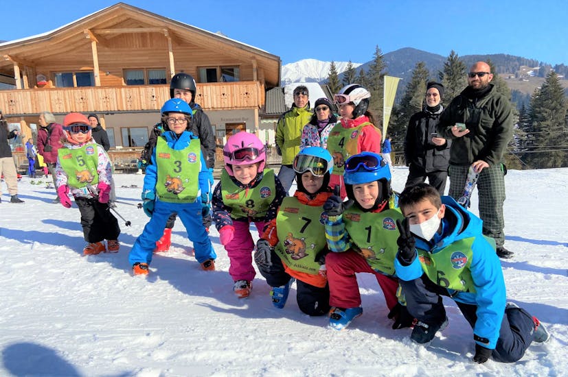 Gruppo di bambini a fondo pista dopo lezione di sci per avanzati con la scuola di sci Dobbiaco.