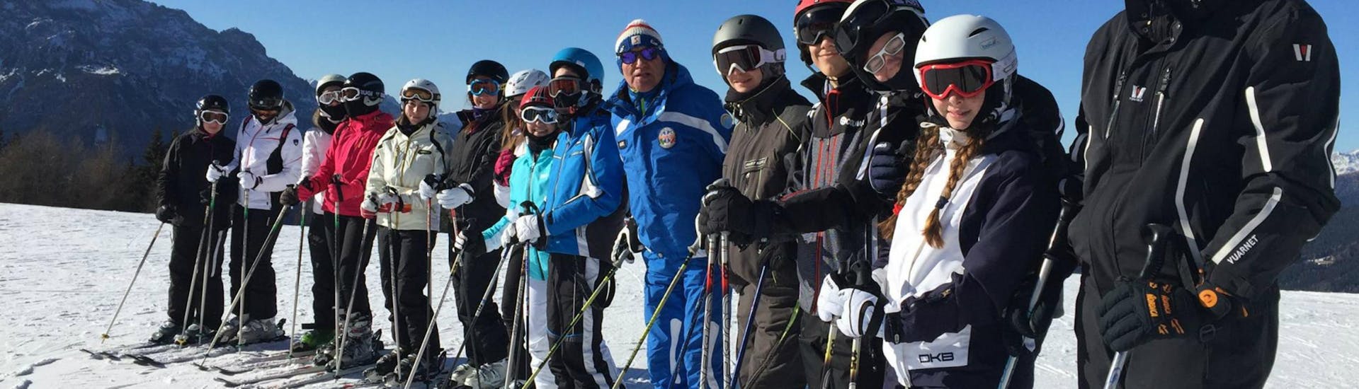 Gruppe von Erwachsenen, die in Toblach das Skifahren lernen.