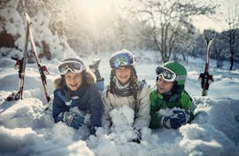 Three children have fun in the snow during their kids ski lessons with the Jennerkids TreffAktiv ski school.