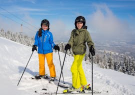 Zwei Skifahrern warten auf der Piste während sie den Skikurs für Erwachsene bei der Skischule Jennerkids TreffAktiv besuchen.