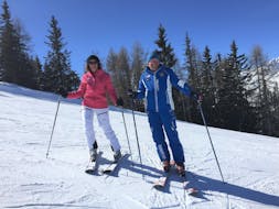 Maestro della scuola di sci Dobbiaco con alunna durante lezione privata di sci per adulti di tutti i livelli.