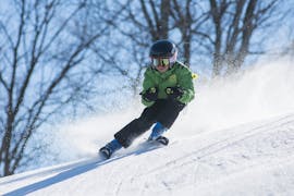 A child races down the slopes during his private ski lessons for kids and teens for all levels at the Jennerkids TreffAktiv ski school.