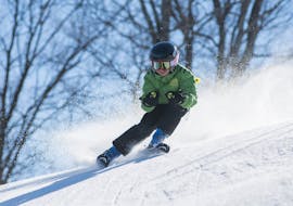 A child races down the slopes during his private ski lessons for kids and teens for all levels at the Jennerkids TreffAktiv ski school.