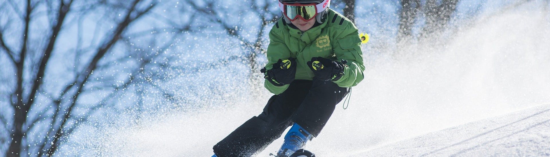 Een kind racet de hellingen af tijdens zijn privé skilessen voor kinderen en tieners voor alle niveaus bij de skischool Jennerkids TreffAktiv.