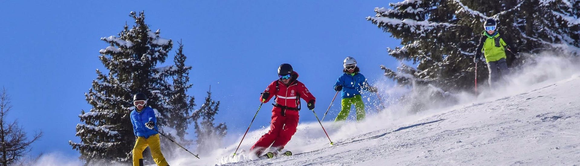 Des skieurs pendant un cours de ski pour enfants pour les skieurs expérimentés à l'école de ski de Jochberg.