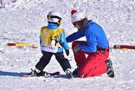 Ein Skilehrer hilft einem Kind beim privaten Skikurs für Kinder aller Niveaus in Jochberg mit der Skischule Jochberg.