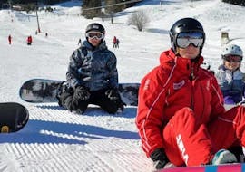 Un groupe de snowboarders pendant leurs cours de snowboard pour enfants et adultes pour débutants avec l'école de ski Jochberg à Jochberg.