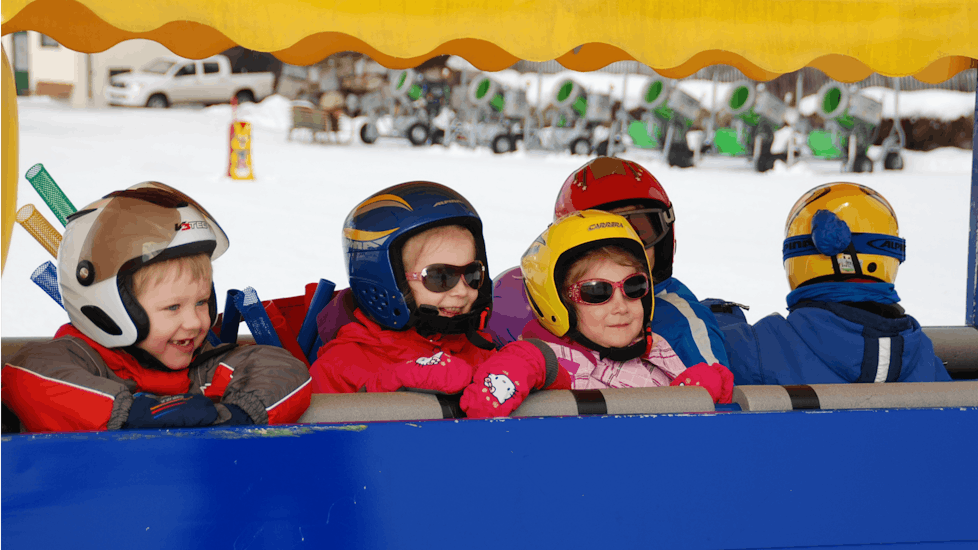 Eine Gruppe Kinder lächelt während ihrem Kinder-Skikurs “Murmis Mini Club” (2½-4 J.) für Anfänger mit Skischule Ski Total Kirchdorf.